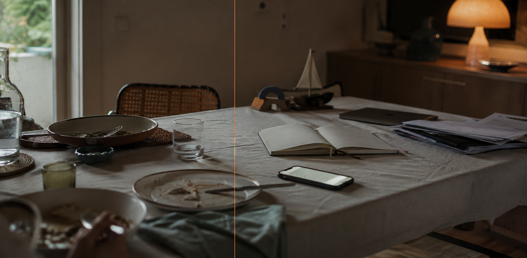 Mesa familiar ao final do dia com pratos, telemóvel, caderno e documentos de trabalho ainda presentes.
